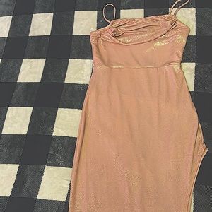 long sparkly rose gold dress with a slit on one side of the dress